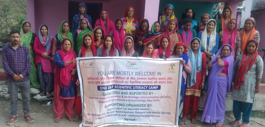 Women and organizers pose together after a community video consultation programme.